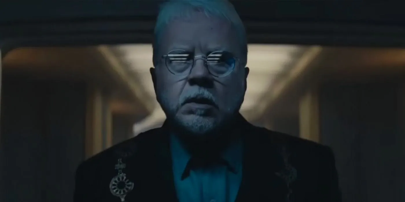 Bernard (Tim Robbins) looking in fear at the screen in his ceremonial outfit in Silo