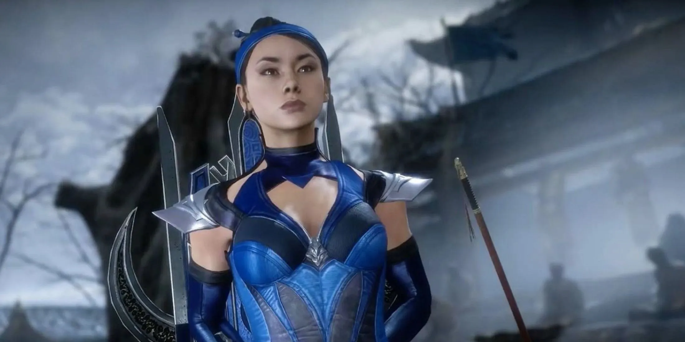 Kitana از Mortal Kombat که با اطمینان در لباس آبی نمادین خود ایستاده است