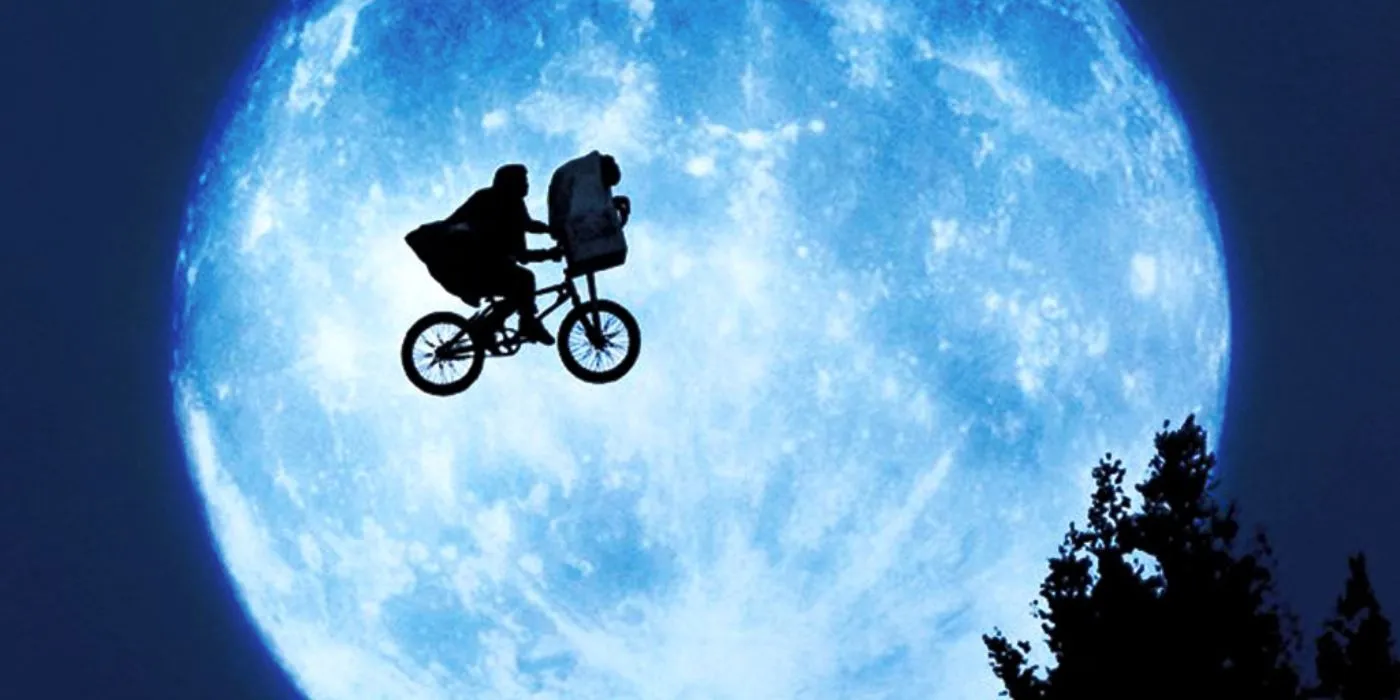 E.T. هنوز دوچرخه سواری در آسمان شب، با ماه در پس زمینه.